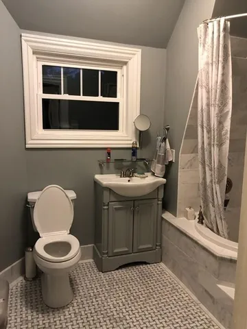 a bathroom with a toilet sink and mirror