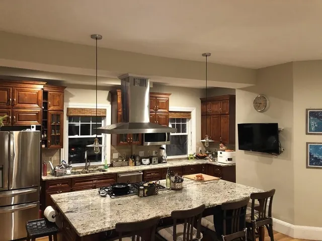 a kitchen with a table chairs microwave and refrigerator