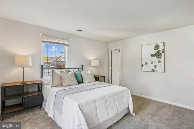 a bedroom with a bed a mirror and a table