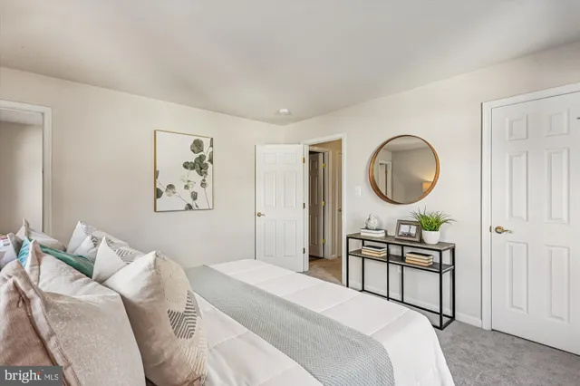 a bedroom with a bed a mirror and a chandelier