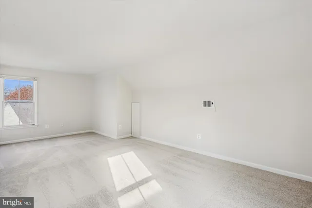 a view of a white house with large windows and a small yard