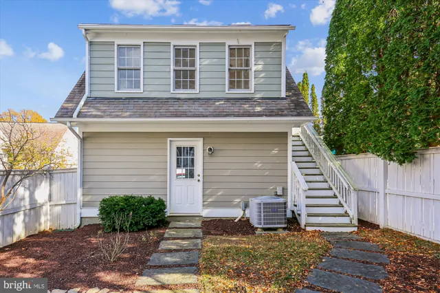 a view of a white house with large windows and palm tree