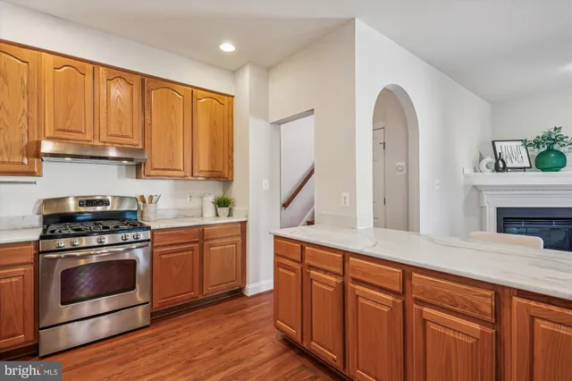 a kitchen with stainless steel appliances granite countertop a stove a sink and cabinets
