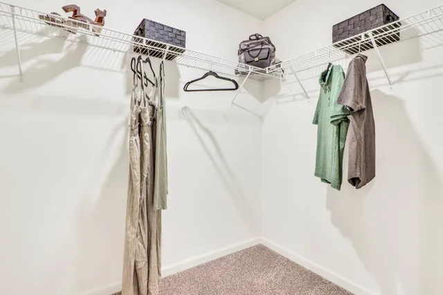a view of walk in closet with clothes and shoes