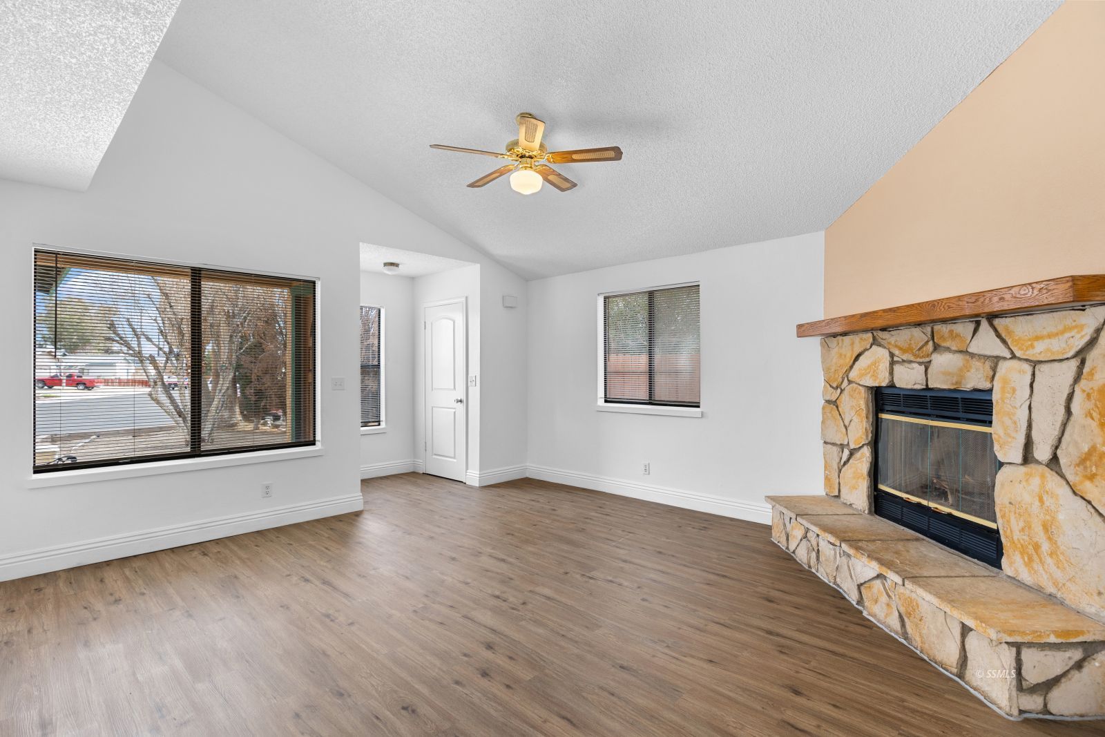 833 Charles Court Ridgecrest, CA 93555 - Photo 7 of 30 a view of an empty room with wooden floor fireplace and a window