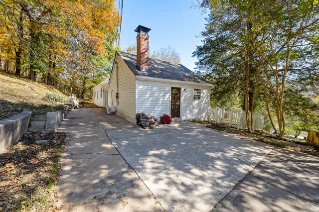 a view of a house with backyard and trees