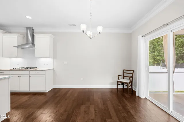 a kitchen with granite countertop a stove a sink and a wooden floor