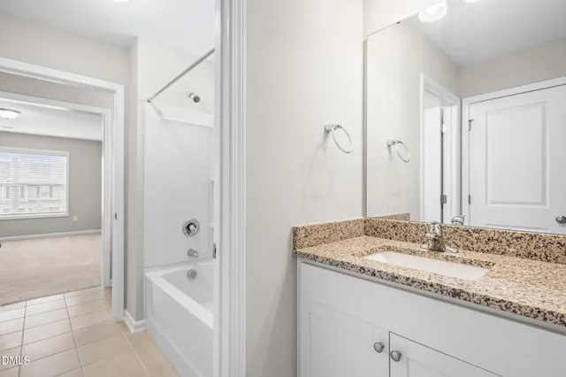 a bathroom with a granite countertop sink tub and a mirror
