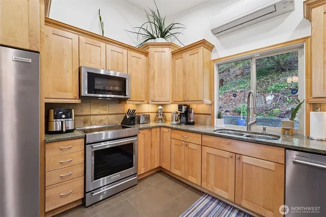 a kitchen with stainless steel appliances a stove a sink and a microwave