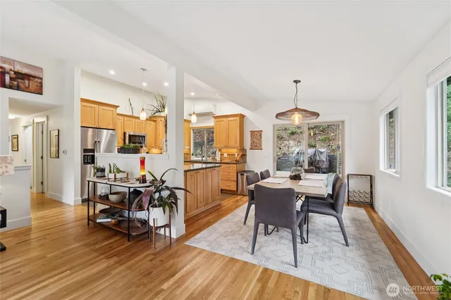 a dining room with wooden floor a chandelier a wooden table and chairs