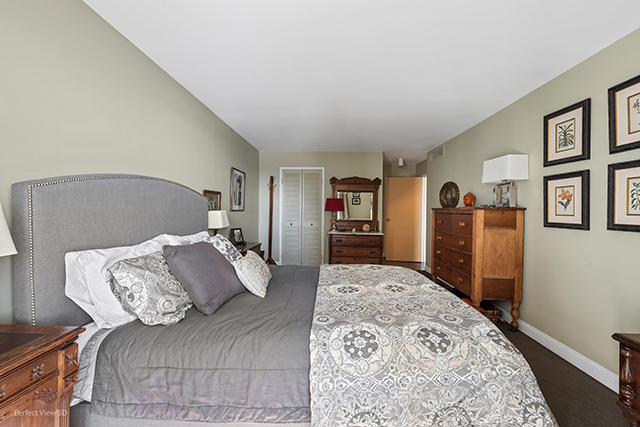 6033 North Sheridan Road, Unit 16A Chicago, IL 60660 - Photo 13 of 21 a bedroom with a large bed and a couch