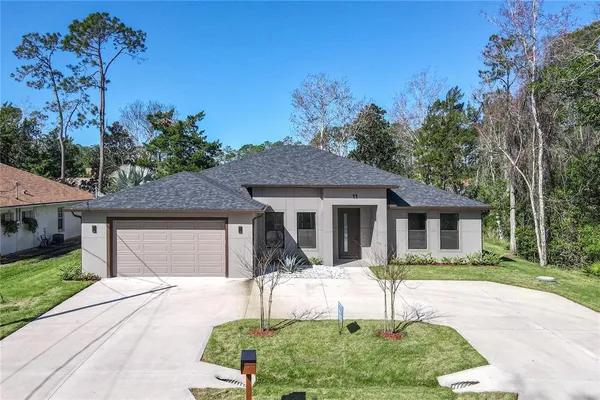 a front view of a house with a yard and potted plants