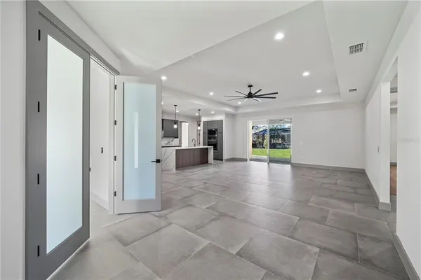 a view of a livingroom with a ceiling fan & entryway