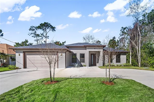a view of a house with a small yard and palm trees