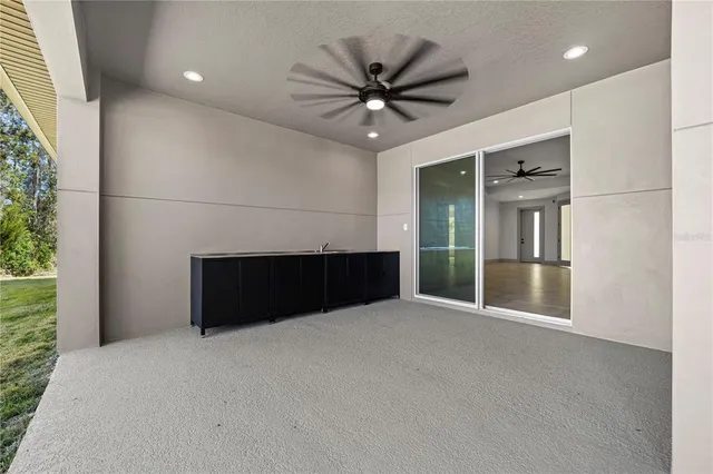 a large kitchen with a sink a counter top space appliances and cabinets