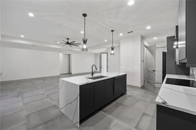 a large kitchen with kitchen island a sink and a refrigerator