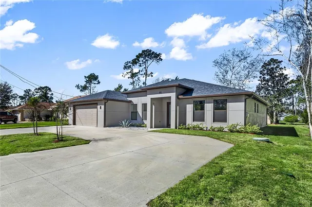 a front view of a house with a yard and trees