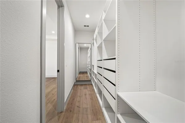a view of empty room with wooden floor and ceiling fan