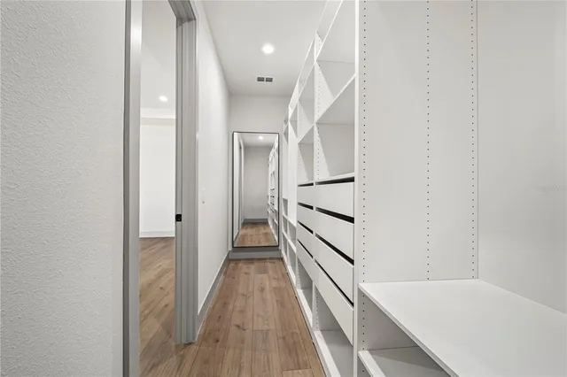 a view of empty room with wooden floor and ceiling fan
