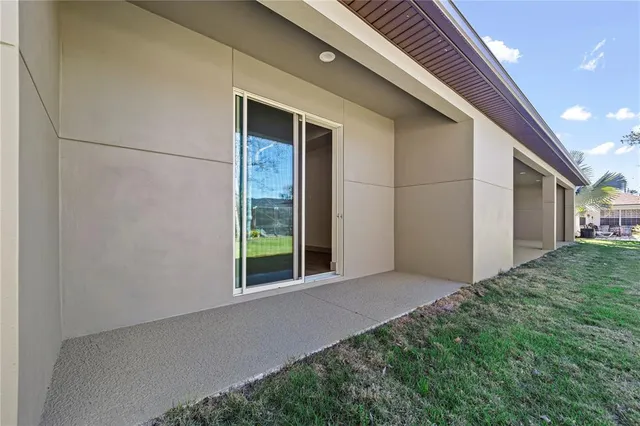an empty room with wooden floor cabinet and a refrigerator