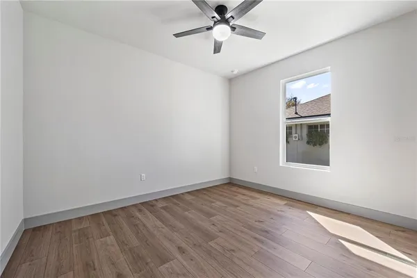 a view of a livingroom with wooden floor and a ceiling fan