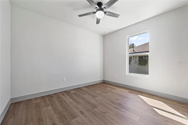 a view of a livingroom with wooden floor and a ceiling fan