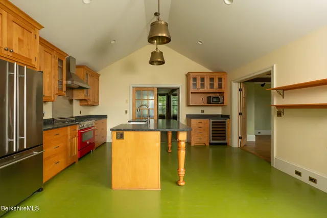 a kitchen with stainless steel appliances granite countertop a refrigerator and a stove top oven