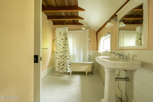 a bathroom with a sink a mirror and a shower