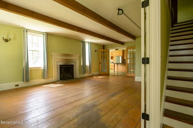 a view of a livingroom with wooden floor and a fireplace