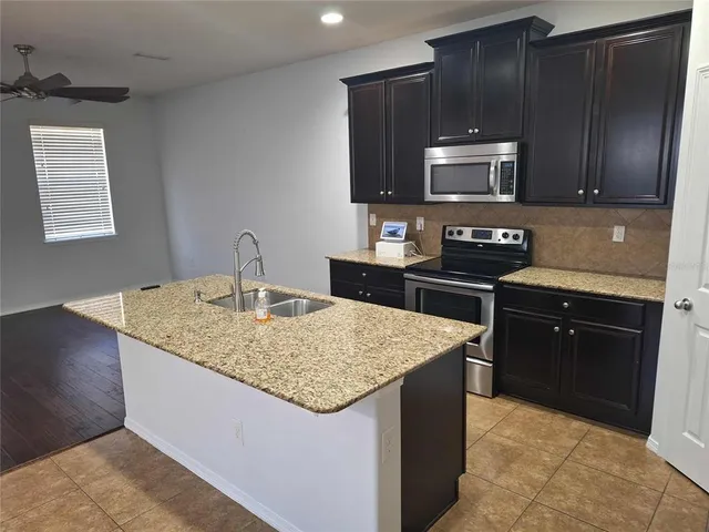a kitchen with stainless steel appliances granite countertop a sink stove and microwave