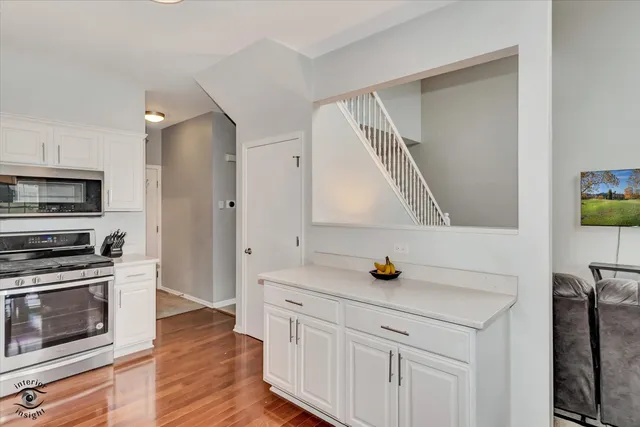 a kitchen with stainless steel appliances a stove cabinets and wooden floor