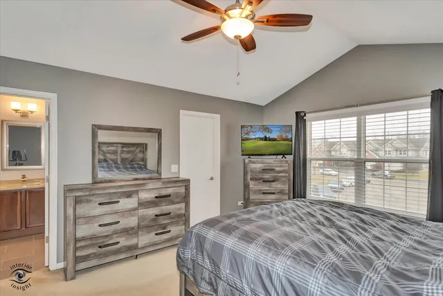 a bedroom with a bed a dresser and a large window
