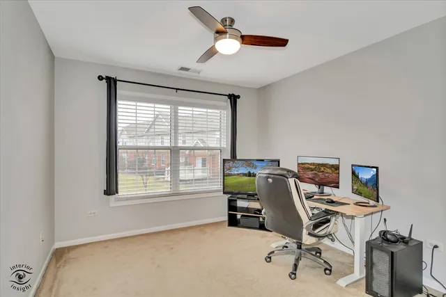a view of a workspace with furniture and a window
