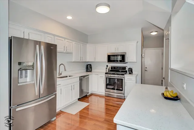 a kitchen with stainless steel appliances granite countertop a refrigerator and a stove