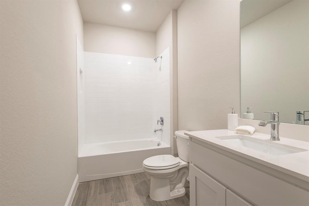 2301 Ruff Road Denton, TX 76205 - Photo 18 of 23 Bathroom featuring a white bathtub with subway tile surround, a built-in shower niche, and a chrome shower fixture