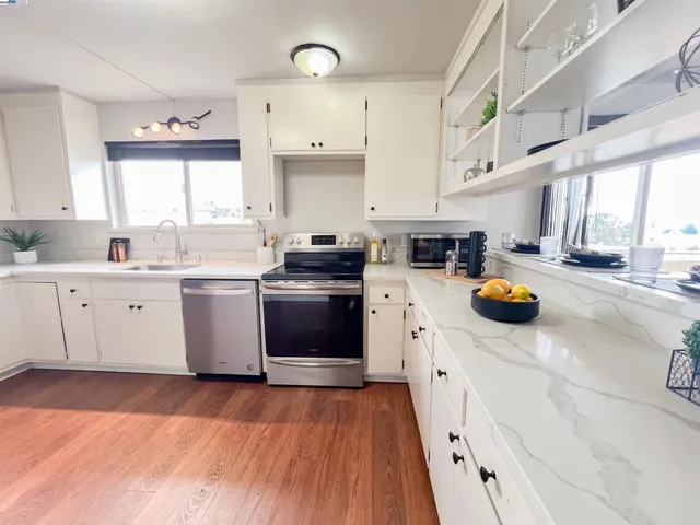 a kitchen that has a sink a stove and a wooden floor
