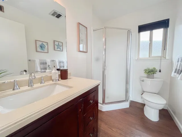 a bedroom with a bed and a lamp on dresser