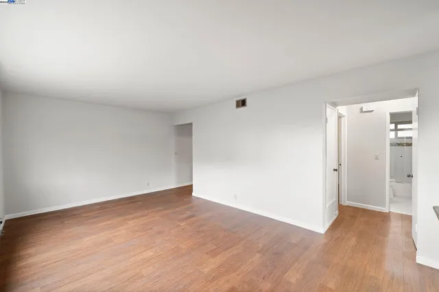 a kitchen with stainless steel appliances granite countertop a refrigerator sink stove and wooden floor