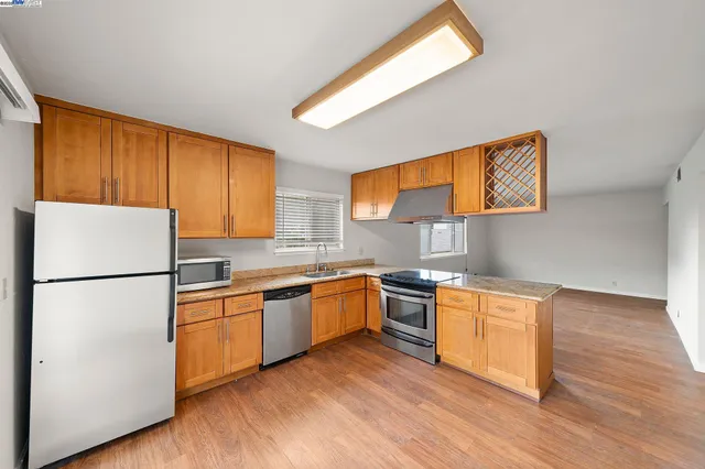 a view of kitchen with wooden floor and electronic appliances