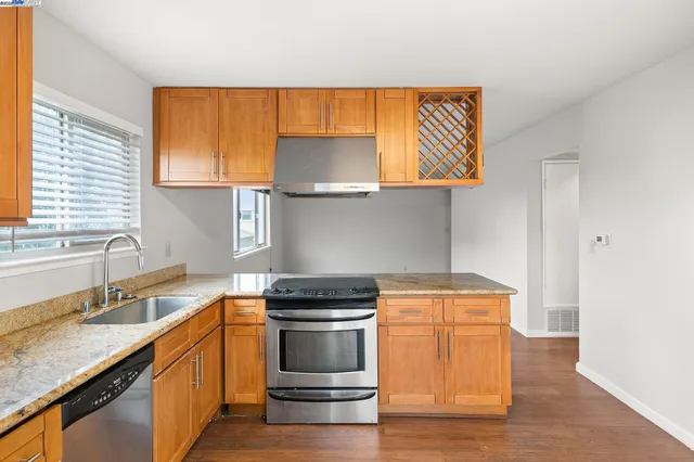 a kitchen with stainless steel appliances granite countertop a stove a sink and a refrigerator