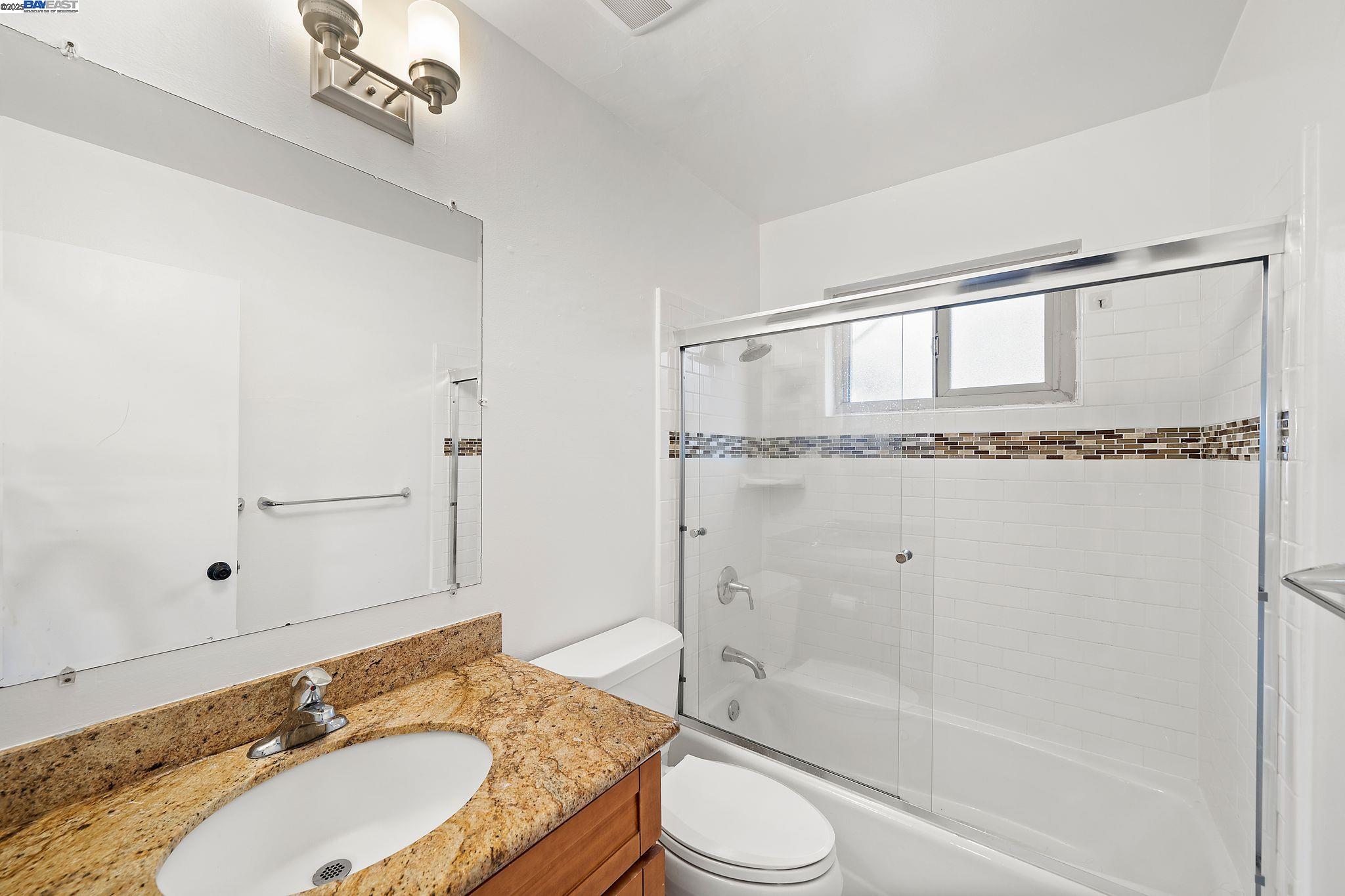 1444 Walnut Street Berkeley, CA 94709 - Photo 36 of 58 a bathroom with a granite countertop sink toilet and shower