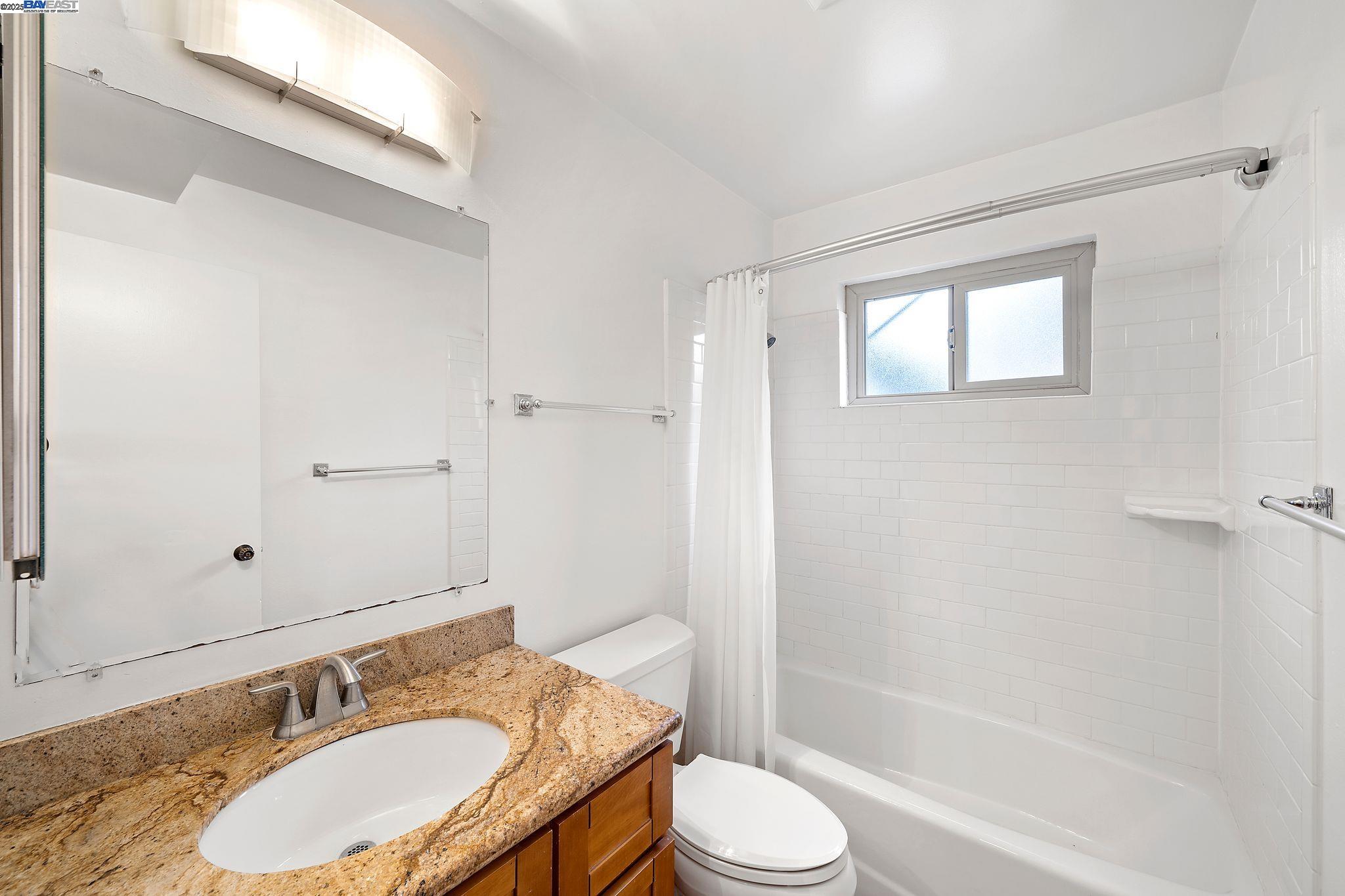 1444 Walnut Street Berkeley, CA 94709 - Photo 40 of 58 a bathroom with a granite countertop sink toilet a mirror and shower