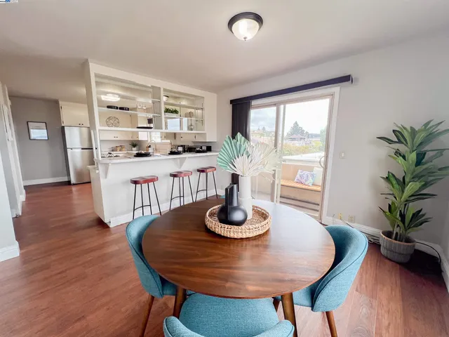 a kitchen with a table chairs refrigerator and cabinets