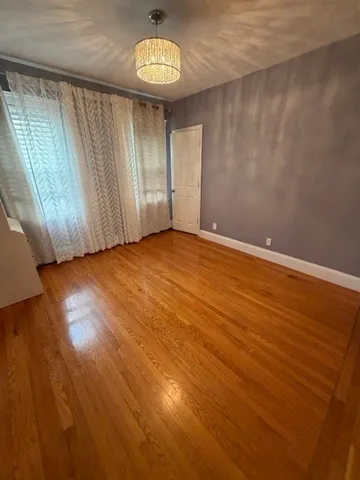 an empty room with a wooden floor and a window