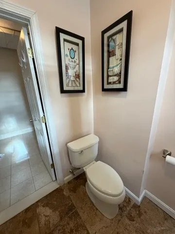 a white toilet sitting next to a shower
