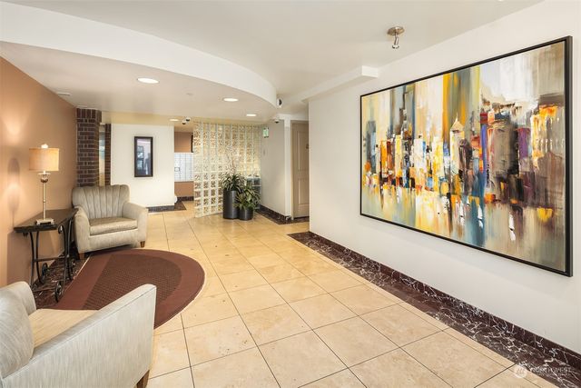 a living room with furniture and a painting on the wall