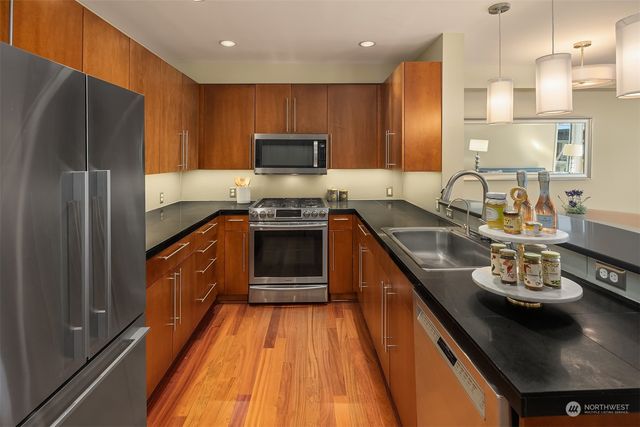 a kitchen with stainless steel appliances granite countertop a sink stove and refrigerator
