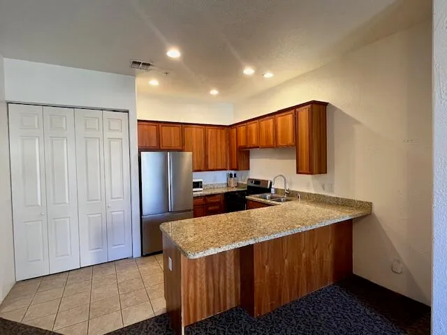 a kitchen with stainless steel appliances granite countertop a refrigerator and a sink