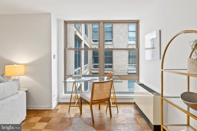 a view of a living room and kitchen with furniture and floor to ceiling window