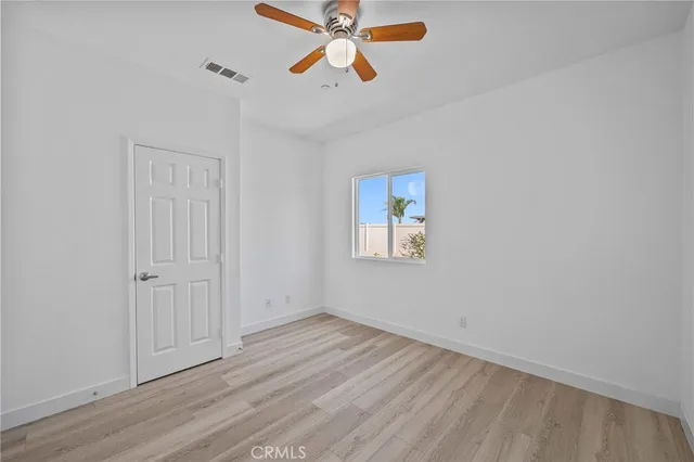 an empty room with windows and fan